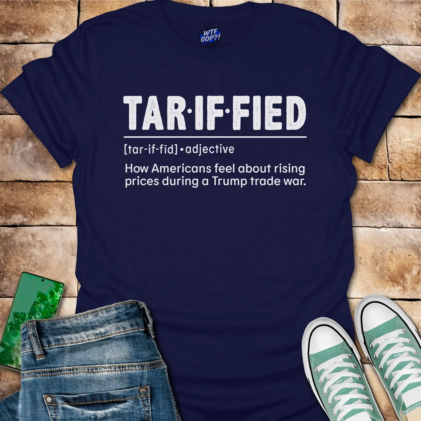Navy blue t-shirt with 'TAR-IF-FIED' text on a wooden surface with jeans and sneakers.