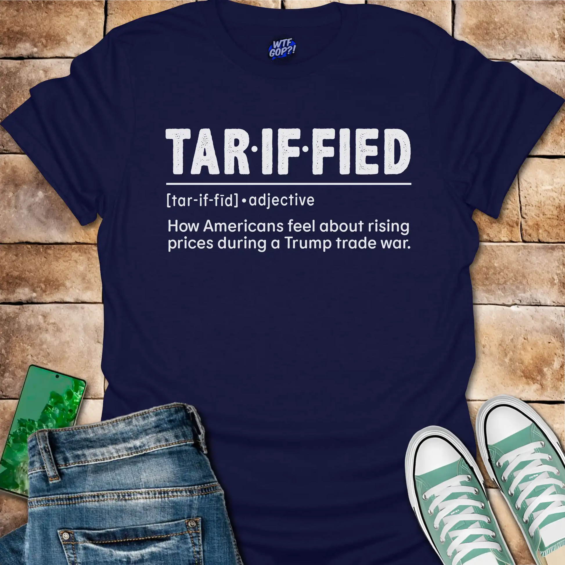 Navy blue t-shirt with 'TAR-IF-FIED' text on a wooden surface with jeans and sneakers.
