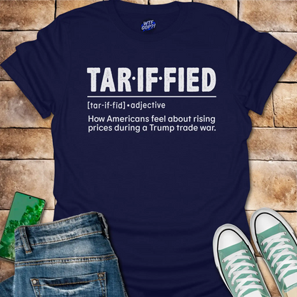 Navy blue t-shirt with 'TAR-IF-FIED' text on a wooden surface with jeans and sneakers.