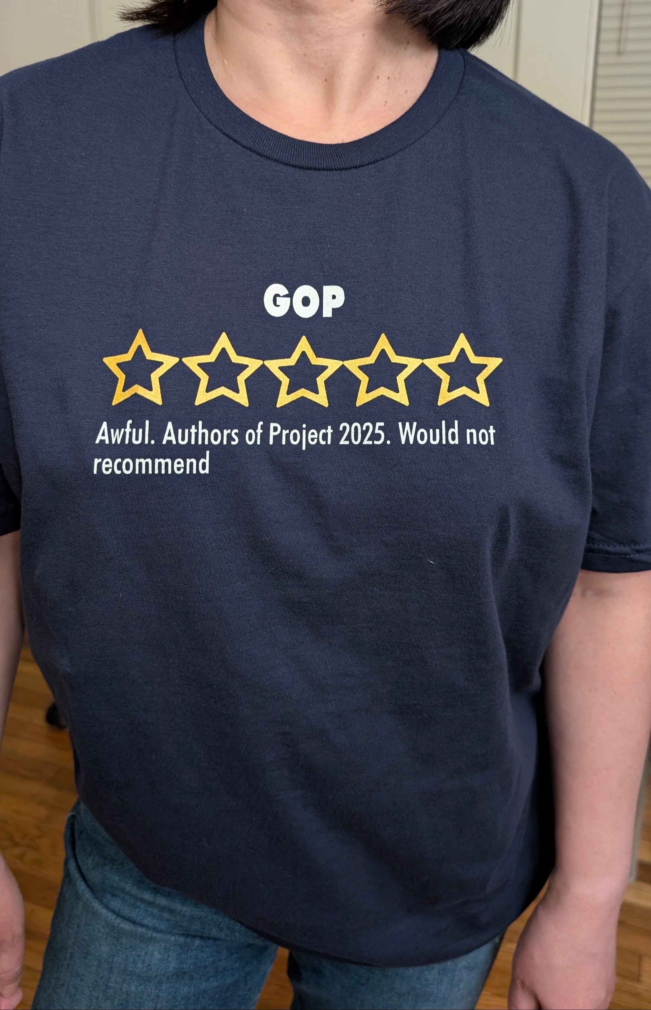 Person wearing a navy blue t-shirt with a five-star rating graphic and text.